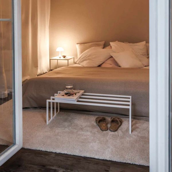 Arrimo Porta Zapatos Borub Blanco en un dormitorio con cama